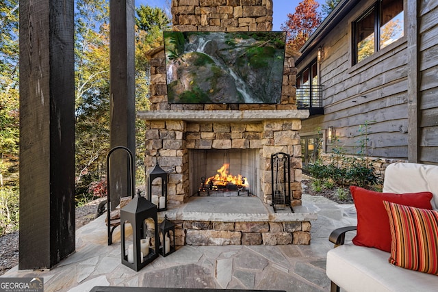 view of patio / terrace with a balcony and an outdoor stone fireplace