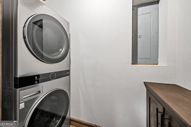 laundry room with electric panel and stacked washer and dryer