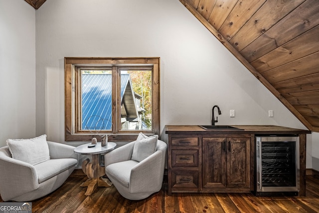 bar with dark hardwood / wood-style floors, beverage cooler, lofted ceiling, and sink