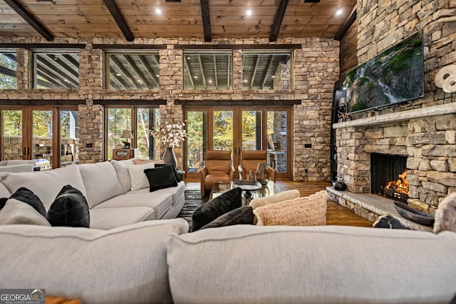 living room featuring french doors, beam ceiling, hardwood / wood-style flooring, wooden ceiling, and a fireplace