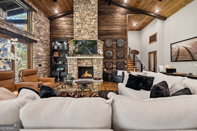 living room with a stone fireplace, wood ceiling, and high vaulted ceiling