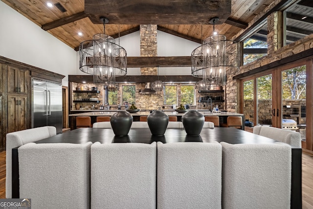 dining space featuring beam ceiling, light hardwood / wood-style flooring, high vaulted ceiling, and wood ceiling