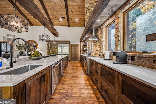 kitchen featuring stainless steel appliances, sink, pendant lighting, an inviting chandelier, and light hardwood / wood-style floors