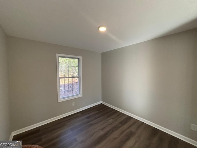 unfurnished room with dark wood-type flooring