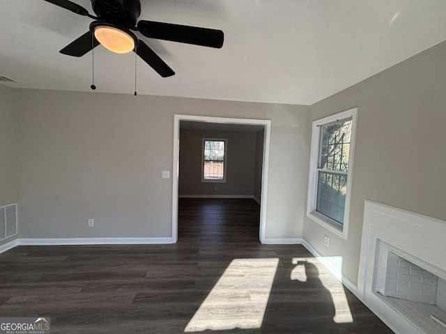 unfurnished living room with ceiling fan and dark hardwood / wood-style flooring