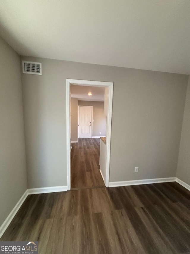 unfurnished room featuring dark wood-type flooring