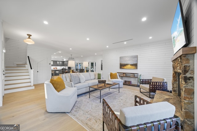 living room with light hardwood / wood-style flooring and a stone fireplace