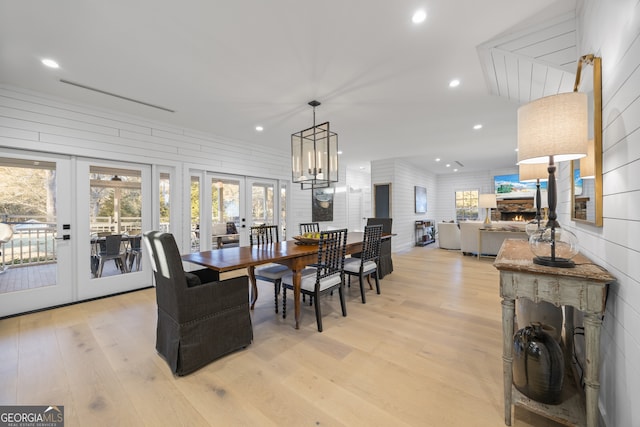 dining space featuring french doors, light hardwood / wood-style floors, and a notable chandelier