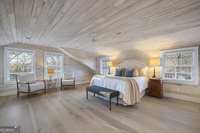 bedroom featuring wood walls, wooden ceiling, light hardwood / wood-style flooring, and vaulted ceiling