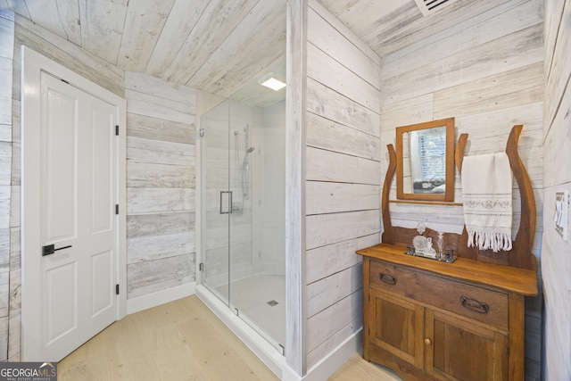 bathroom featuring hardwood / wood-style floors, wooden ceiling, walk in shower, and wooden walls