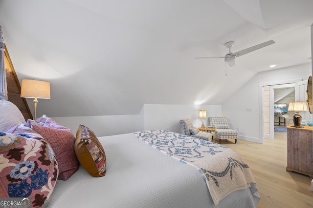 bedroom featuring ceiling fan, light hardwood / wood-style floors, and lofted ceiling