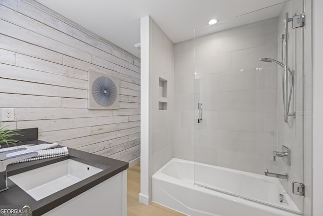 bathroom featuring vanity, tiled shower / bath, and wooden walls