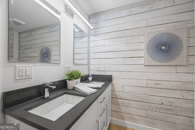 bathroom featuring hardwood / wood-style flooring, vanity, and wooden walls