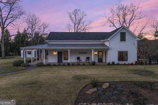 view of front of home with a porch and a lawn