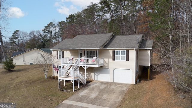 view of front of house featuring roof with shingles, a porch, stairway, an attached garage, and driveway