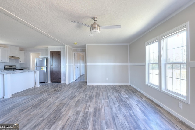 unfurnished living room featuring ornamental molding, a textured ceiling, ceiling fan, and dark wood-type flooring