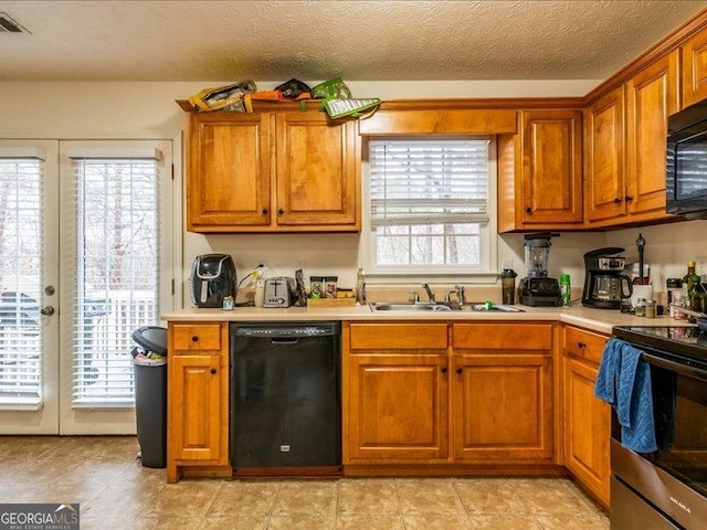 kitchen featuring black appliances, a textured ceiling, sink, and french doors