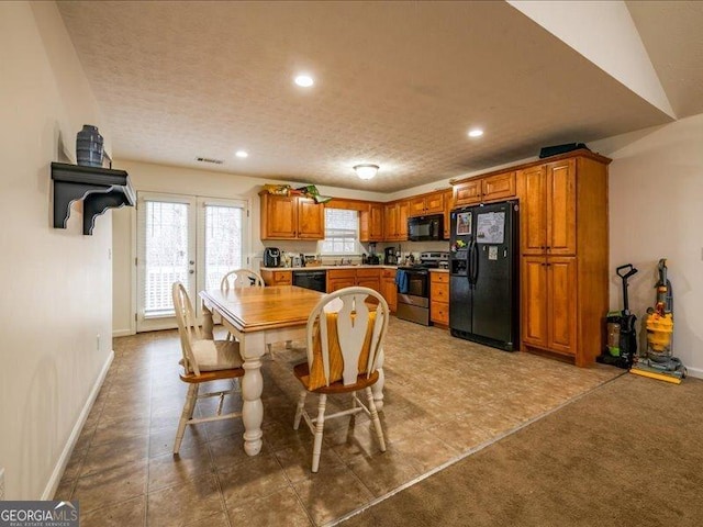 dining space with a textured ceiling, sink, carpet floors, and french doors