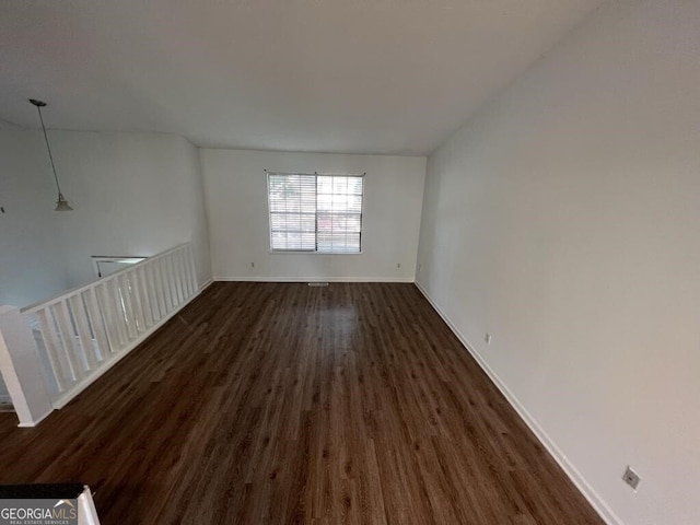 unfurnished room featuring dark wood-type flooring