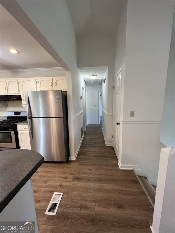 hallway with dark hardwood / wood-style flooring and a high ceiling