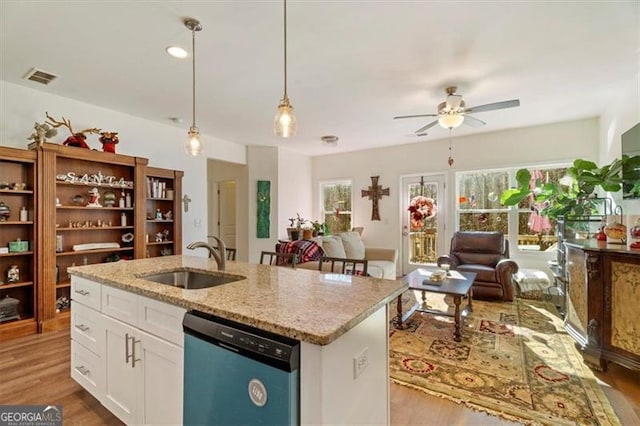 kitchen with white cabinetry, a kitchen island with sink, dishwasher, hanging light fixtures, and sink