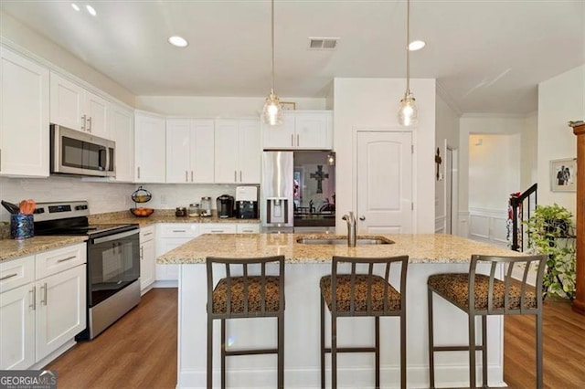 kitchen with sink, a center island with sink, and stainless steel appliances