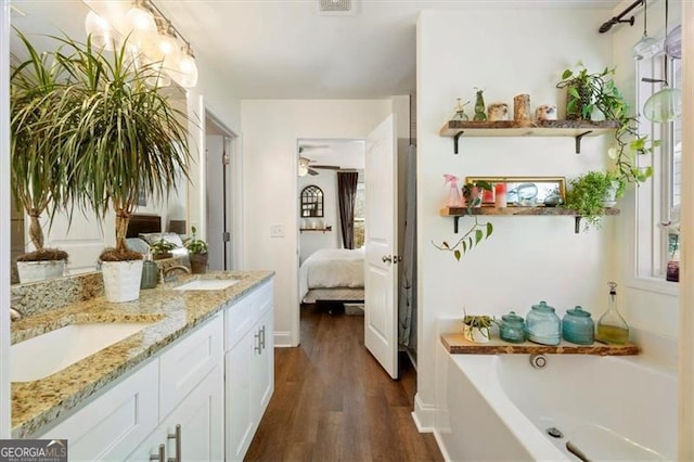 bathroom with ceiling fan, a bathtub, hardwood / wood-style flooring, and vanity