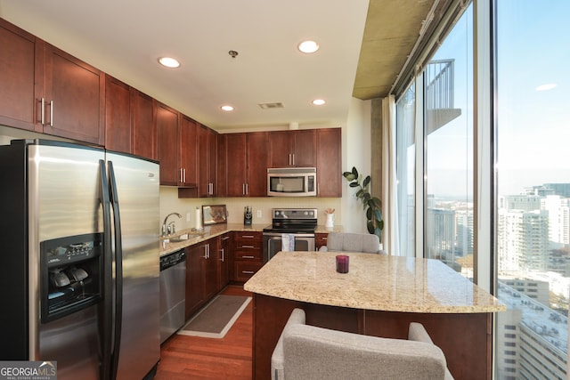 kitchen featuring dark wood-type flooring, plenty of natural light, a kitchen island, and stainless steel appliances