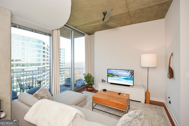 living room featuring ceiling fan, wood-type flooring, and a wealth of natural light