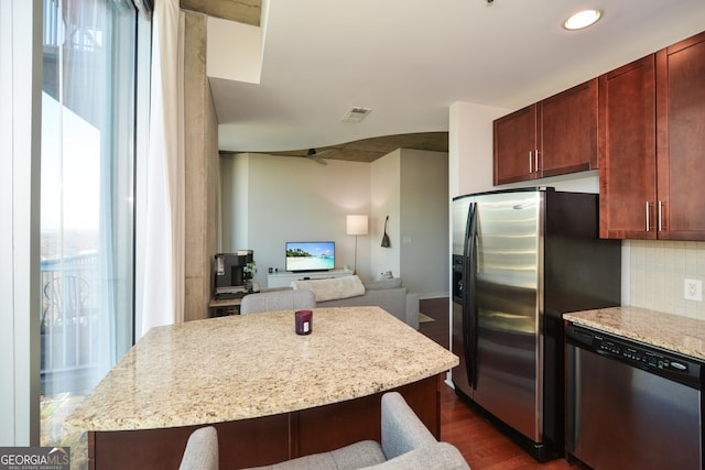 kitchen with decorative backsplash, dark hardwood / wood-style flooring, stainless steel appliances, and a wealth of natural light