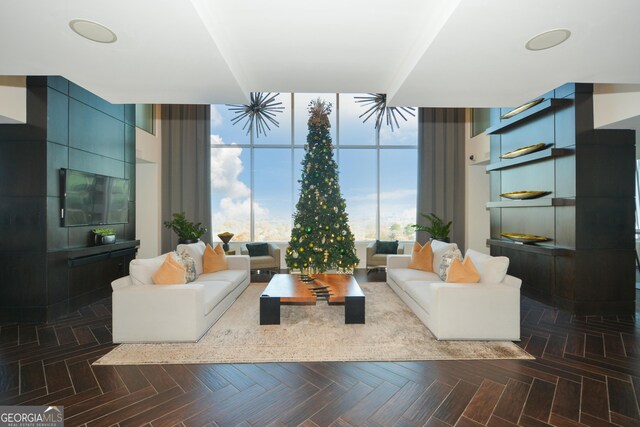 living room with floor to ceiling windows, dark parquet flooring, and an inviting chandelier