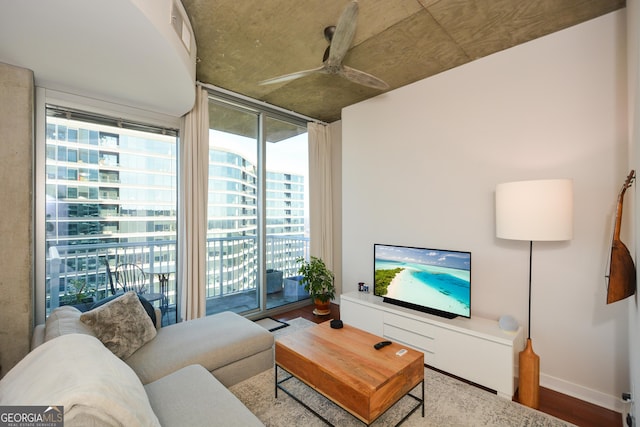 living room featuring ceiling fan, hardwood / wood-style floors, and a wall of windows