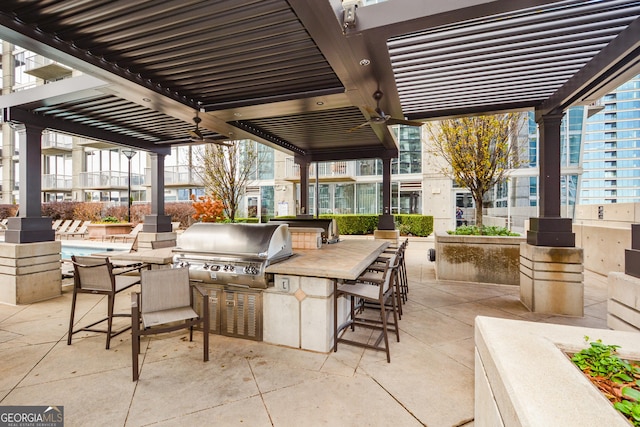 view of patio with ceiling fan, exterior kitchen, a pergola, exterior bar, and area for grilling