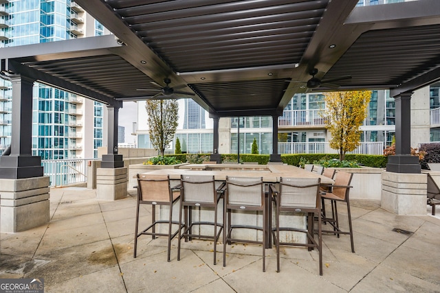 view of patio featuring a bar and ceiling fan