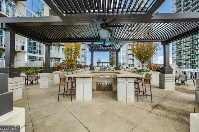 view of patio with a pergola, ceiling fan, and a bar