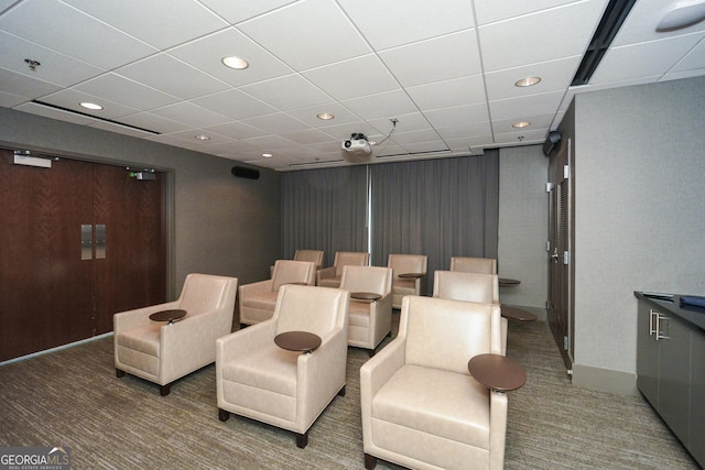 home theater room with a drop ceiling and carpet