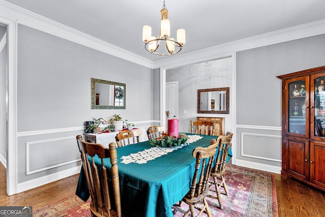 dining room with dark wood-type flooring, a notable chandelier, and ornamental molding