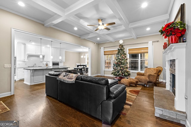 living room featuring dark hardwood / wood-style flooring, coffered ceiling, ceiling fan, a tile fireplace, and beamed ceiling