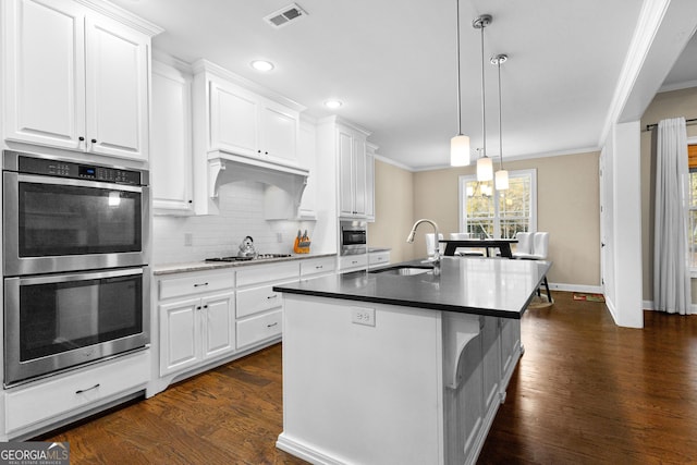 kitchen with dark hardwood / wood-style flooring, white cabinetry, and stainless steel appliances