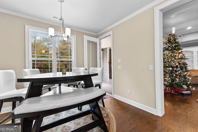 dining area with dark hardwood / wood-style floors, crown molding, and a chandelier