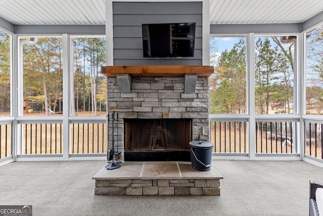 sunroom / solarium with wood ceiling, a fireplace, and a healthy amount of sunlight