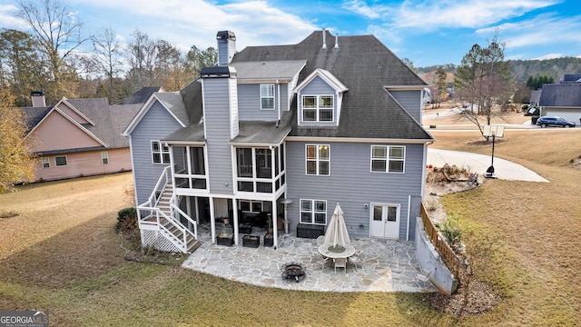 back of house with a sunroom, a patio, and a lawn