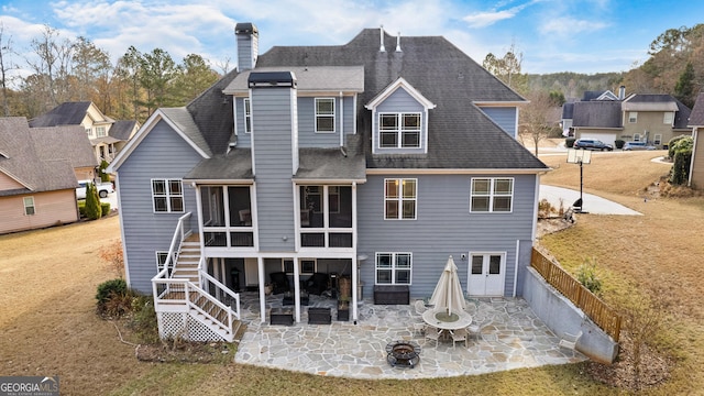 rear view of house with a sunroom, a patio, and a lawn