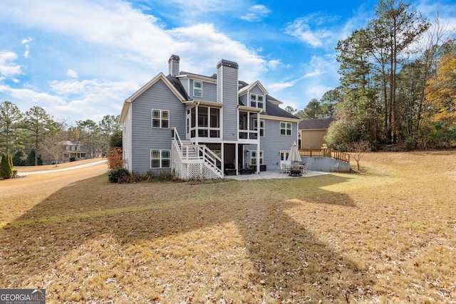 back of property featuring a sunroom, a yard, and a patio