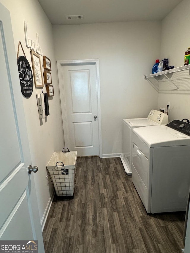 laundry area featuring washing machine and dryer and dark wood-type flooring