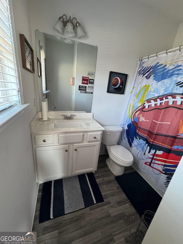 bathroom with hardwood / wood-style floors, vanity, toilet, and a shower with curtain