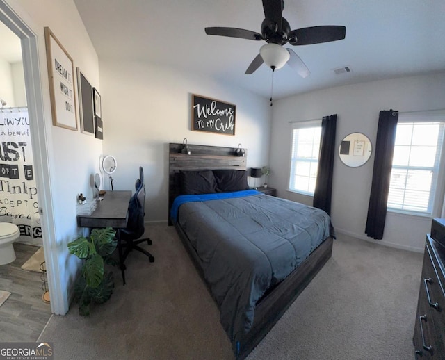 bedroom featuring hardwood / wood-style floors, ceiling fan, and connected bathroom