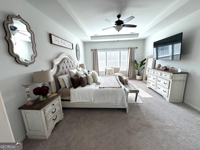 bedroom with carpet, ceiling fan, and a tray ceiling