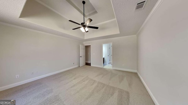 spare room with a raised ceiling, crown molding, and a textured ceiling