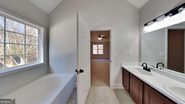 bathroom featuring vanity, vaulted ceiling, tile patterned flooring, ceiling fan, and a tub